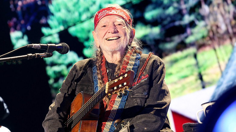Willie Nelson onstage, headband, guitar