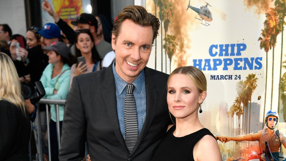 Dax Shepard smiling with arm around Kristen Bell