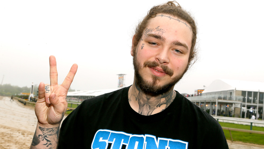 Post Malone holding up a peace sign 