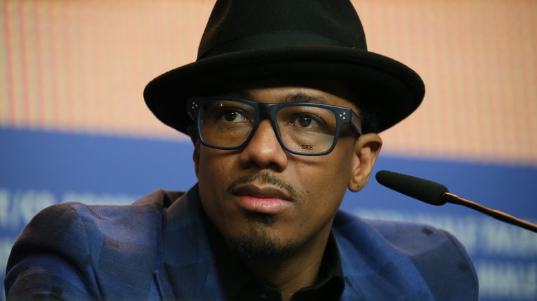 Nick Cannon wearing glasses and a hat 