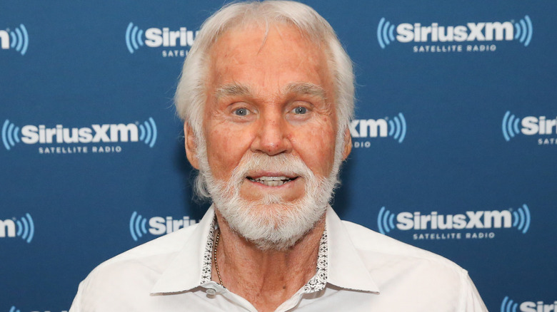 Kenny Rogers smiling in white