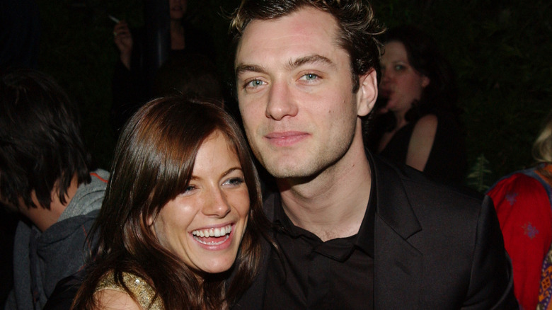 Jude Law and Sienna Miller smiling and laughing