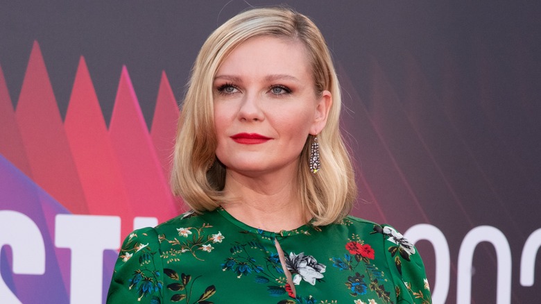 Kirsten Dunst poses on a red carpet