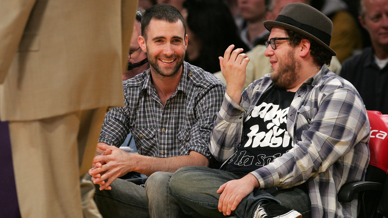 Jonah Hill and Adam Levine sit courtside