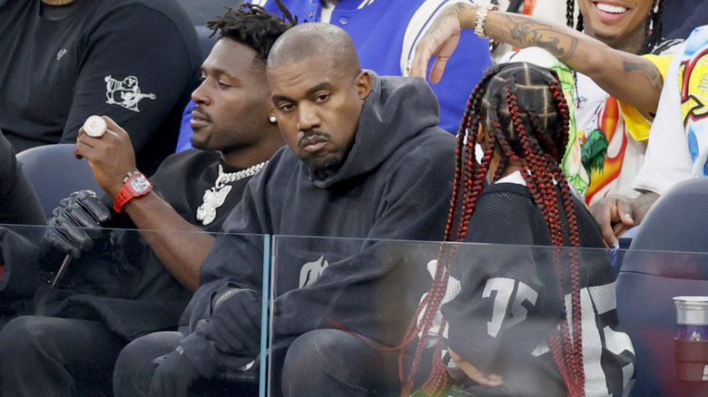 Kanye West glaring among fans, Antonio Brown, and daughter at a game