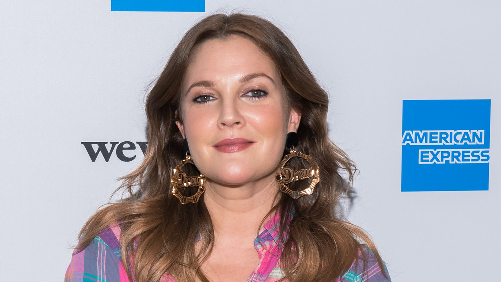 Drew Barrymore standing and looking straight ahead