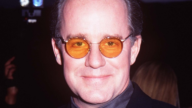 Phil Hartman with glasses, smiling softly