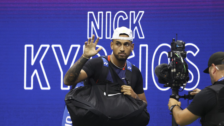 Nick Kyrgios waving on tennis court