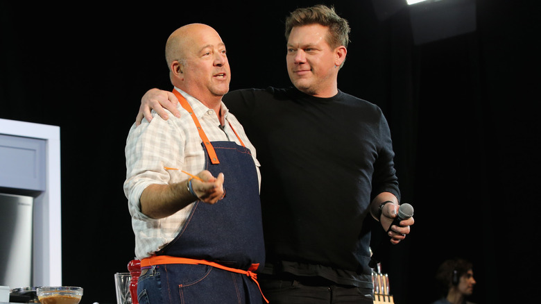 Andrew Zimmern and Tyler Florence embracing