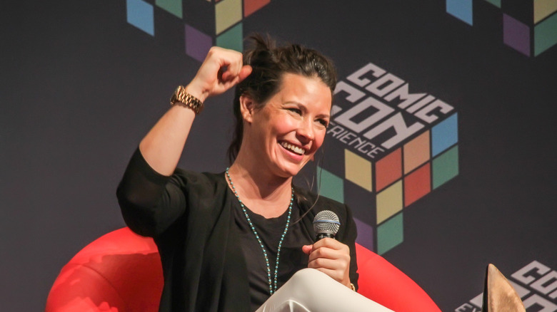 Evangeline Lilly fist pumping in a chair 