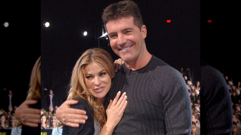 Carmen Electra hugging Simon Cowell with her hand on his chest