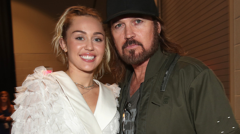 Miley and Billy Ray Cyrus posing 