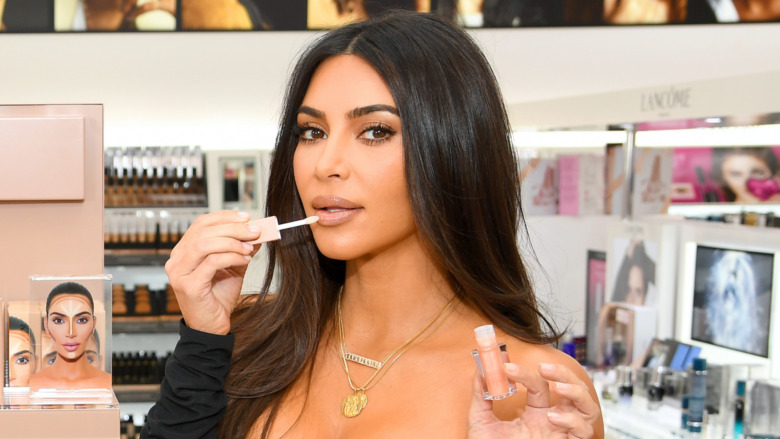 Kim Kardashian applying lip gloss