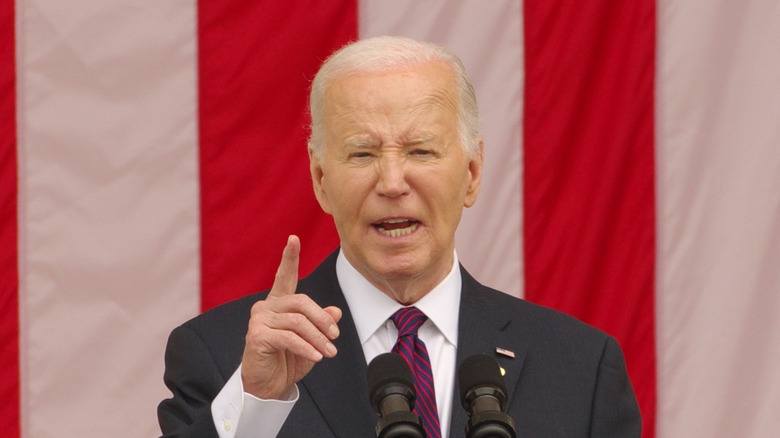 Joe Biden giving a speech in front of red and white flag stripes