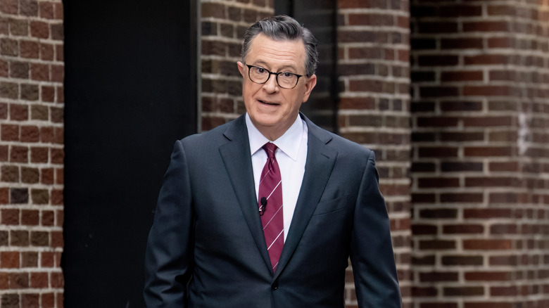 Stephen Colbert in front of a brick building