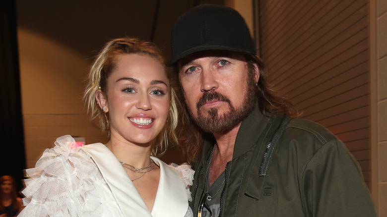 Miley Cyrus posing with Billy Ray Cyrus