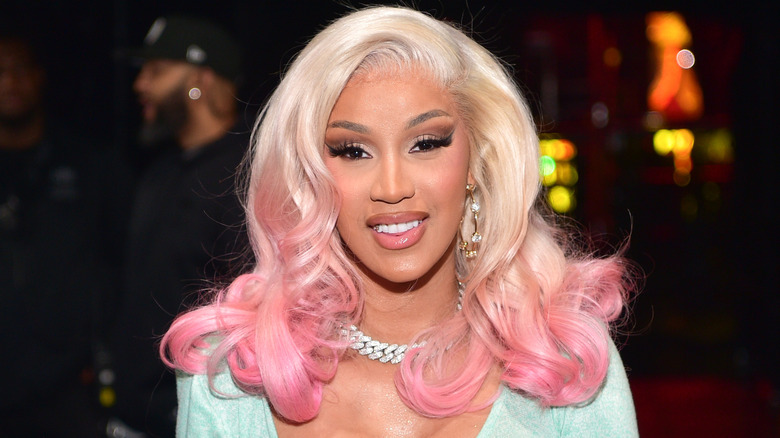 Cardi B smiles in platinum blond hair with pink tips