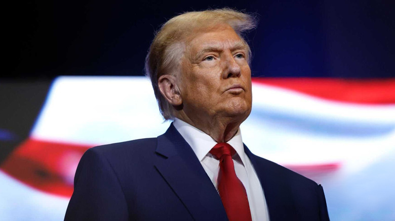 Donald Trump wearing a blue suit and red tie