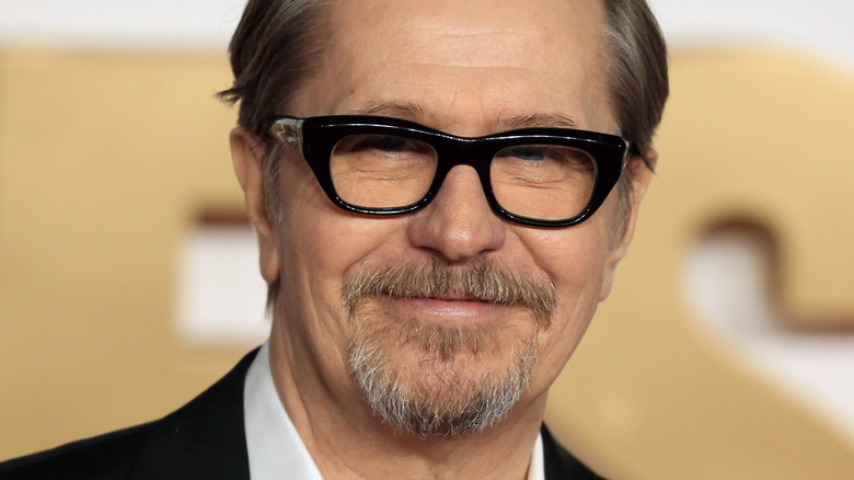 Gary Oldman wearing black glasses