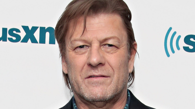 Sean Bean standing in front of a Sirius XM wall