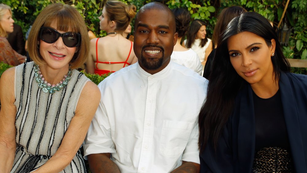 Anna Wintour, Kanye West, Kim Kardashian posing together at a fashion show