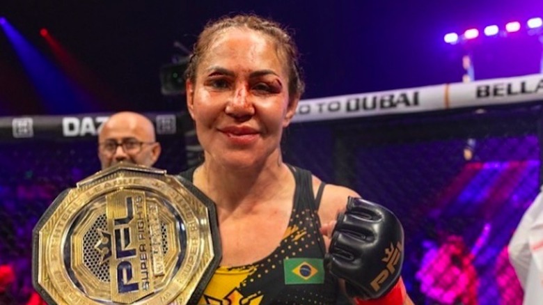 Cris 'Cyborg' Gestino posing with championship belts