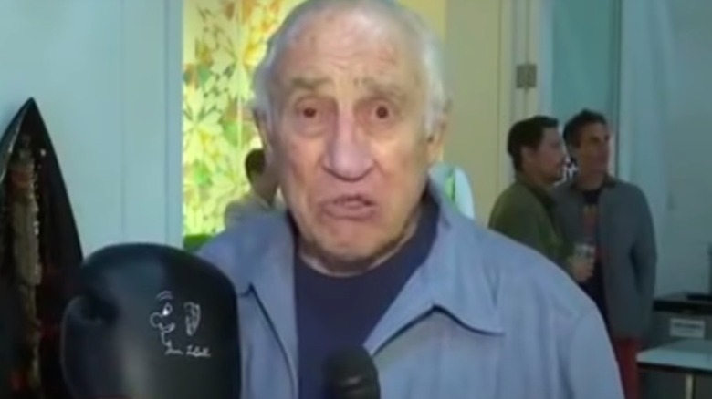 Gene LeBell holding a boxing glove during an interview