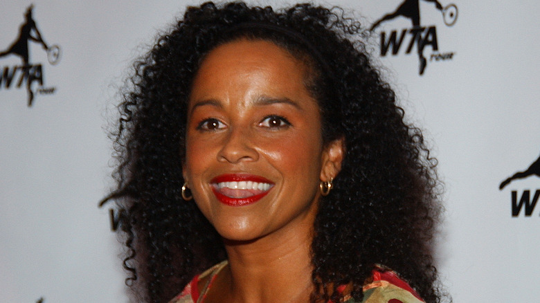 Rae Dawn Chong smiling at event in multi-colored top