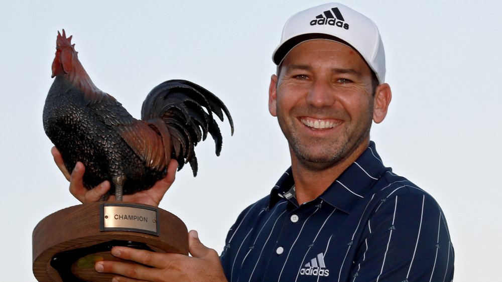 Sergia Garcia smilling and holding a chicken trophy