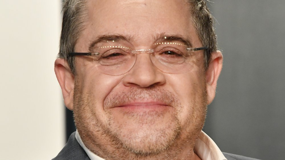 Patton Oswalt wearing glasses, with a small smile