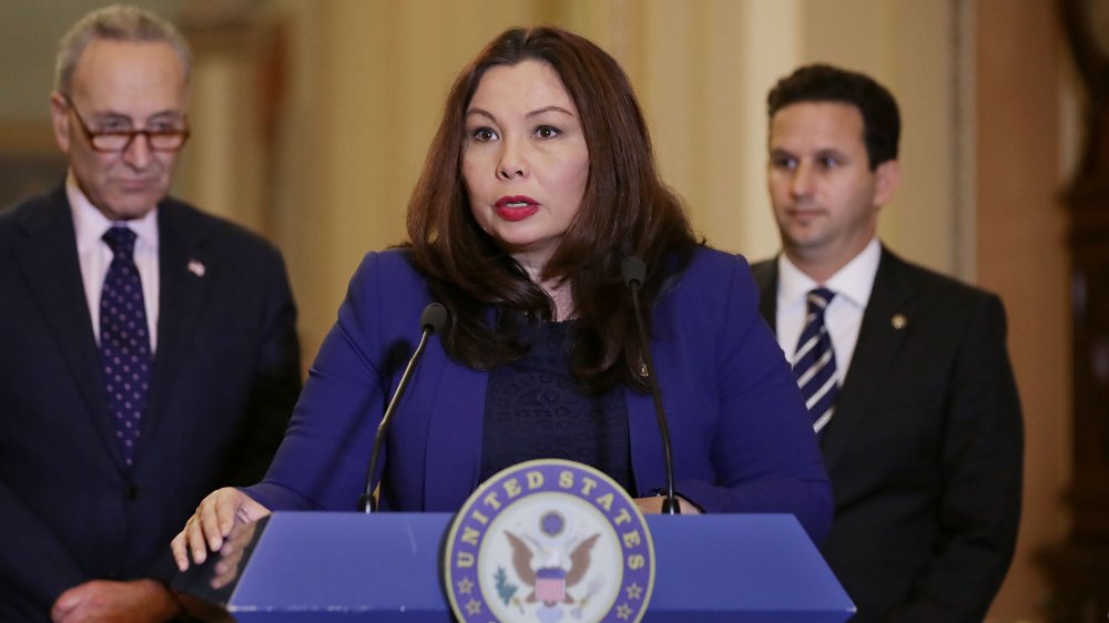 Tammy Duckworth in blue, speaking at the Senate podium