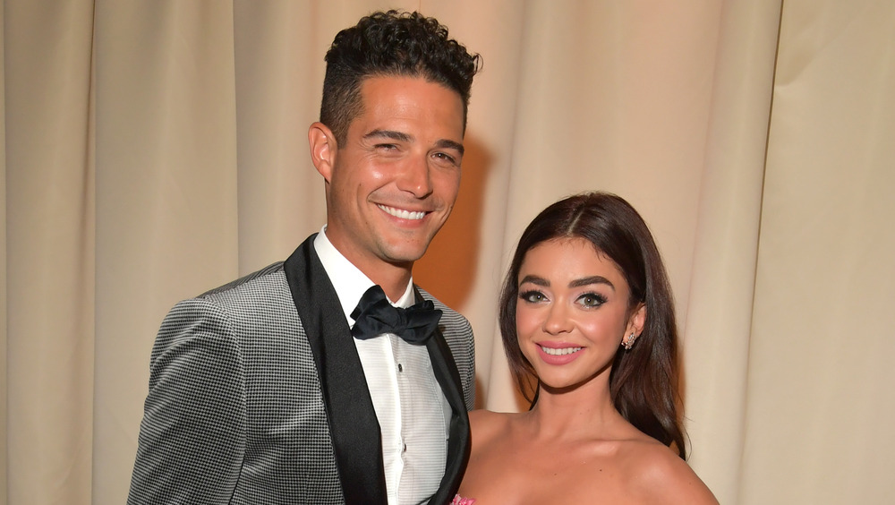 Sarah Hyland and Wells Adams smiling and embracing 