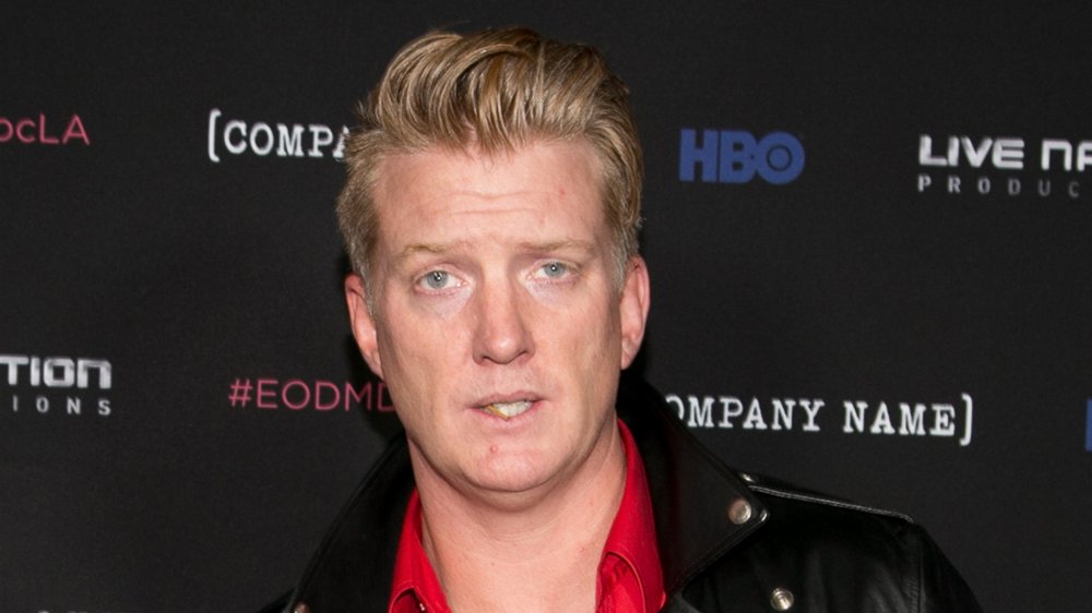 Josh Homme in a leather jacket and red button up shirt