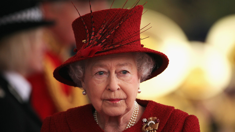 Queen Elizabeth II posing in red hat