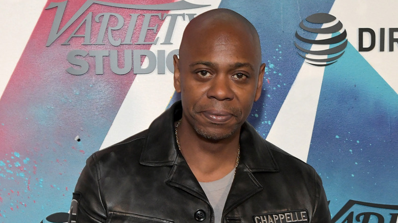 Dave Chappelle wearing a leather jacket