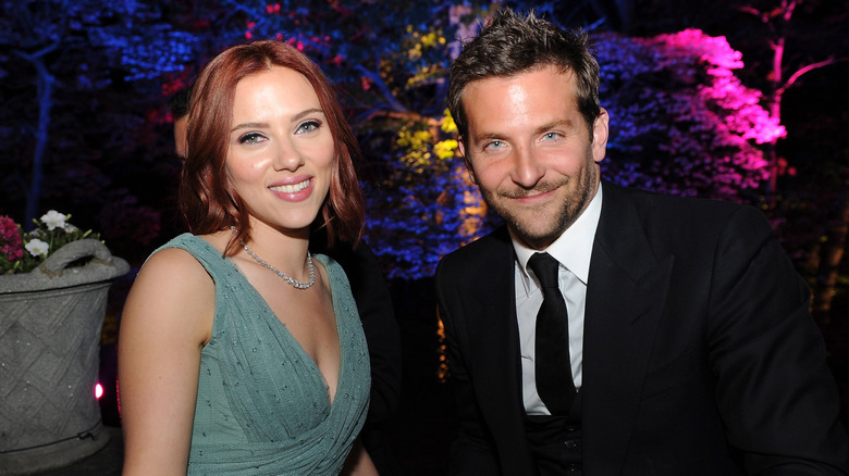 Scarlett Johnasson wearing green dress seated beside Bradley Cooper wearing suit