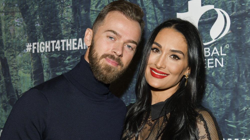 Artem Chigvintsev and Nikki Bella posing at FIGHT4THEAMAZON event