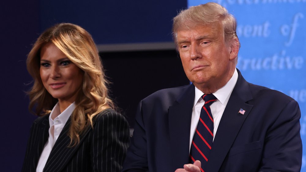 Melania Trump and Donald Trump smiling at a debate 