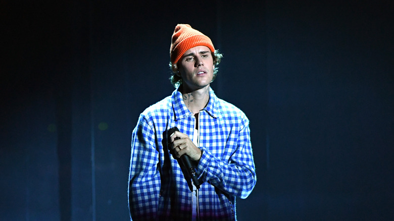 Justin Bieber holding a microphone on stage