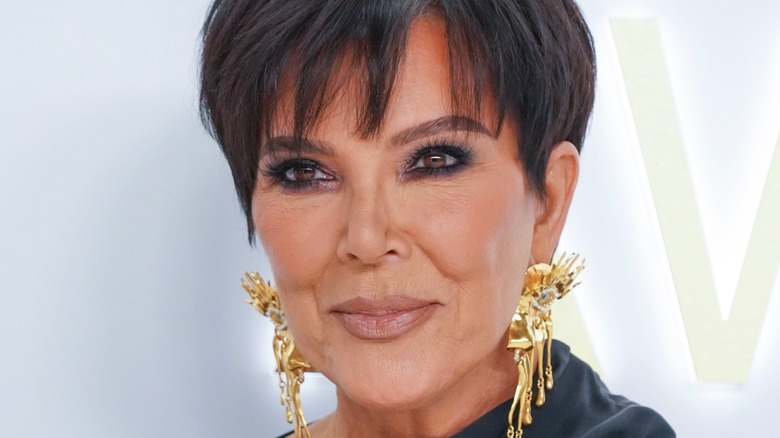 Kris Jenner posing in big gold earrings