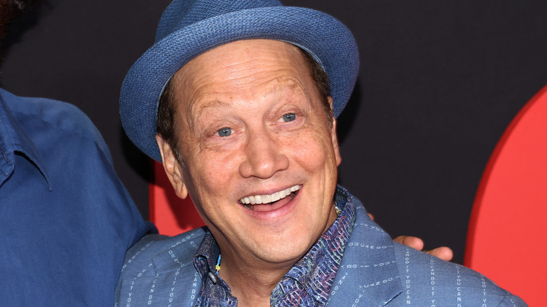 Rob Schneider smiling in hat