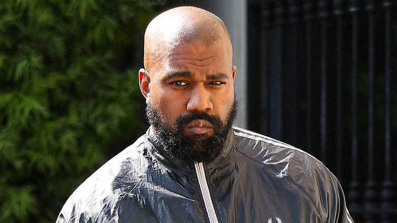 Ye grimacing in a windbreaker