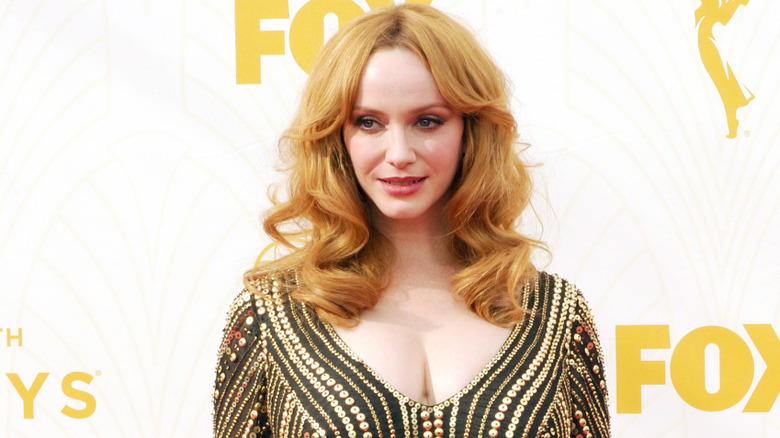 Christina Hendricks with orange blonde hair wearing a jeweled striped long sleeved gown