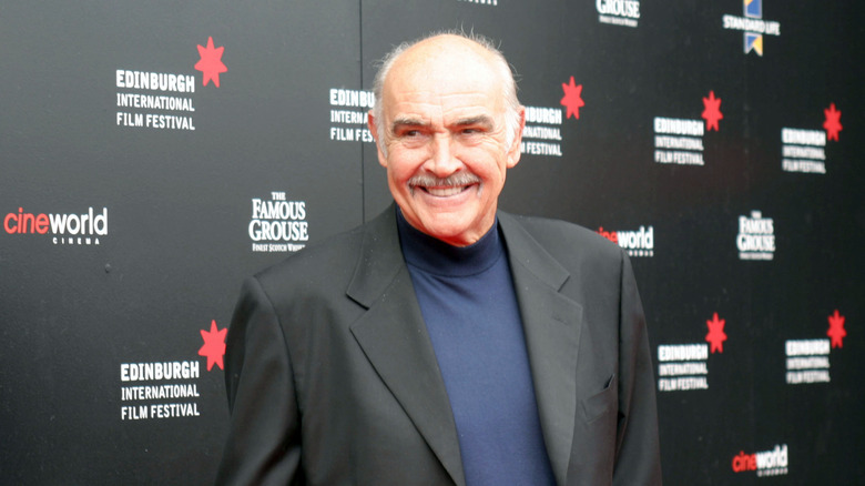 Sean Connery with a bald head wearing a black suit jacket and blue turtleneck at Edinburgh International Film Festival