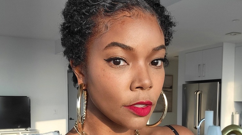 Gabrielle Union wearing her natural waves cropped short with large hoop earrings