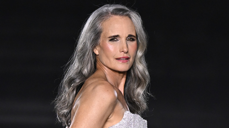 Andie McDowell with long flowing silver hair wearing a sparkling strapless gown