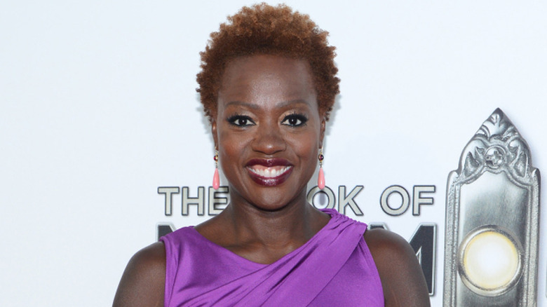 Viola Davis wearing her natural hair while wearing a purple strapless dress