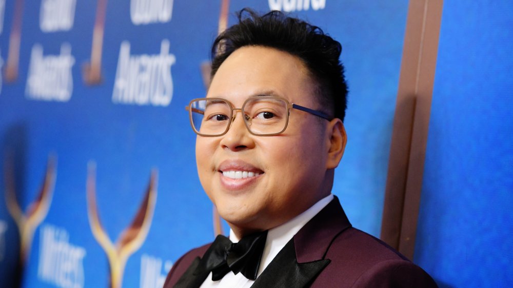 Nico Santos in a maroon suit, posing with a smile on the red carpet