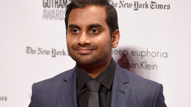 Aziz Ansari wearing posing in suit