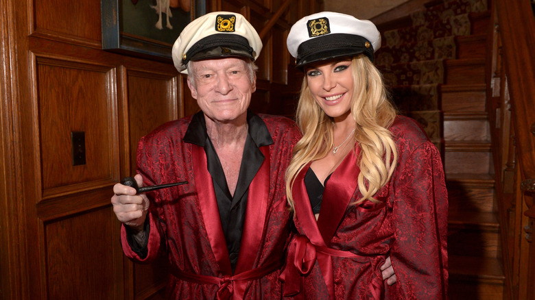 Hugh Hefner and Crystal Harris posing together in matching robes and captain's hats